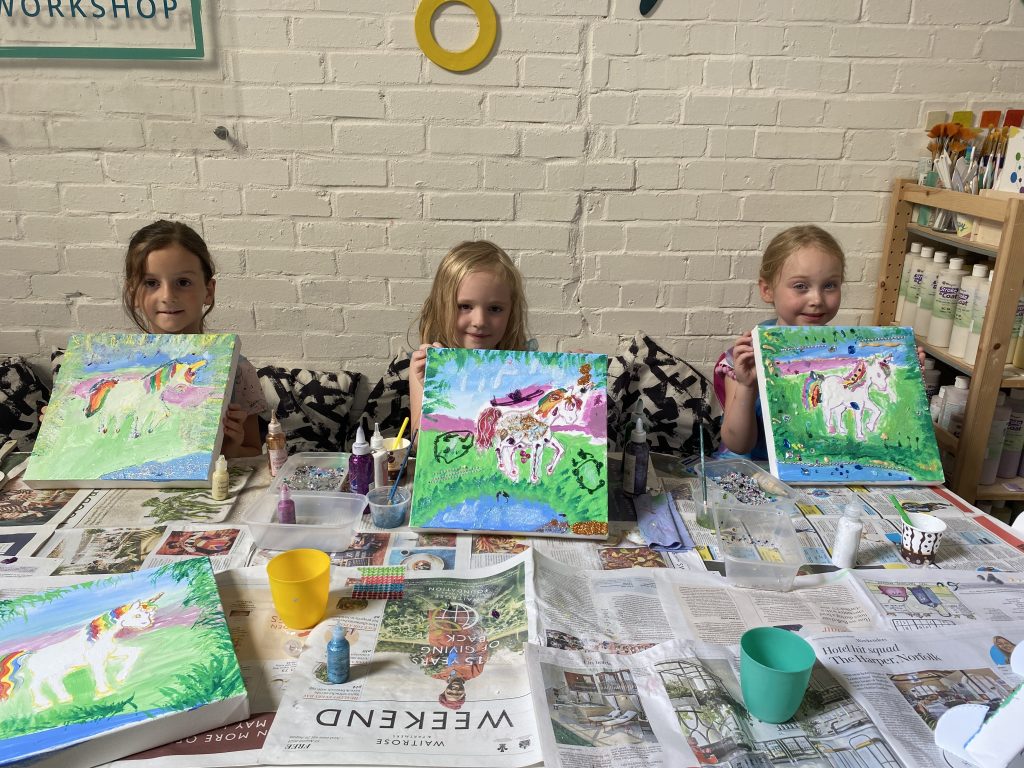 Children smiling with their paintings