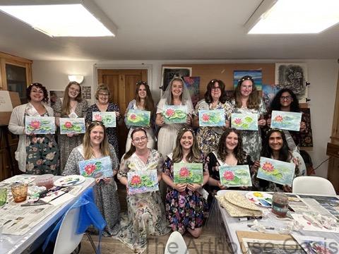A group of ladies with watercolour paintings in their hands