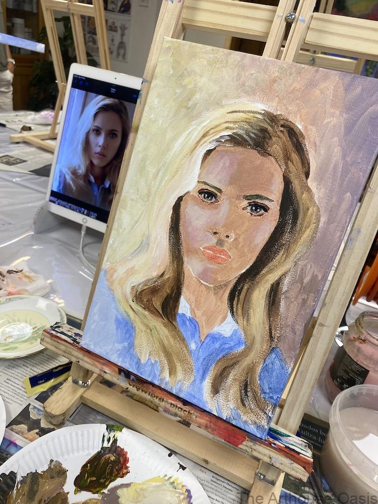 A painted canvas in progress featuring a portrait of Scarlett Johansson