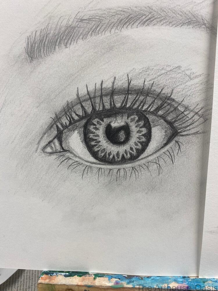 Close-up pencil drawing of a human eye with detailed iris and lashes