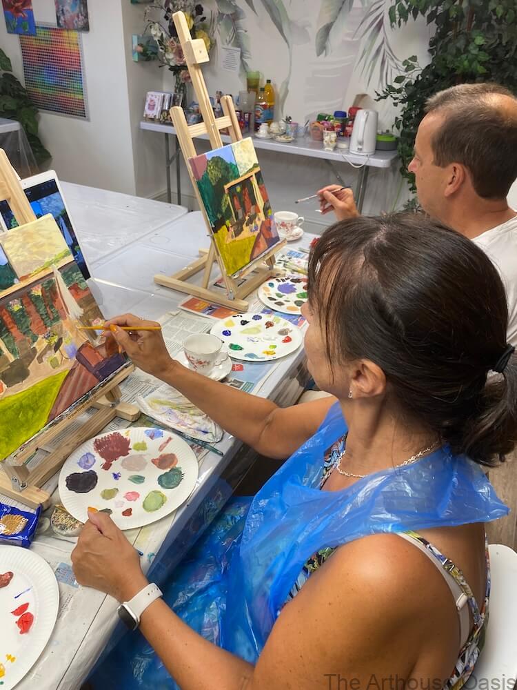Two adults painting a colourful garden scene during an acrylic class in Bishop’s Stortford.