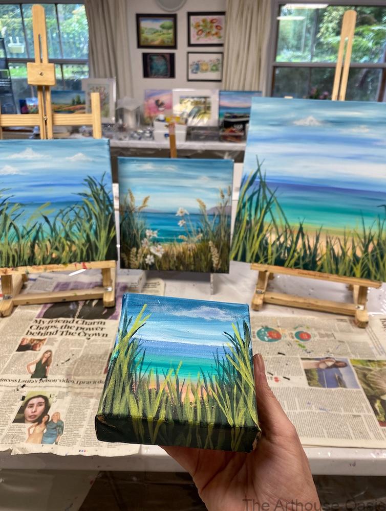 Acrylic coastal paintings featuring sea, sky and beach grasses, created by art students during a guided painting session.