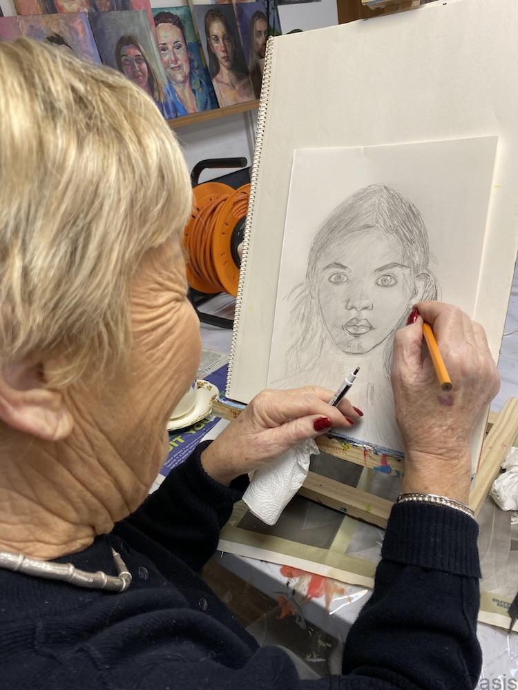 Adult student drawing a pencil portrait on an easel during a one to one art session in Bishop’s Stortford.