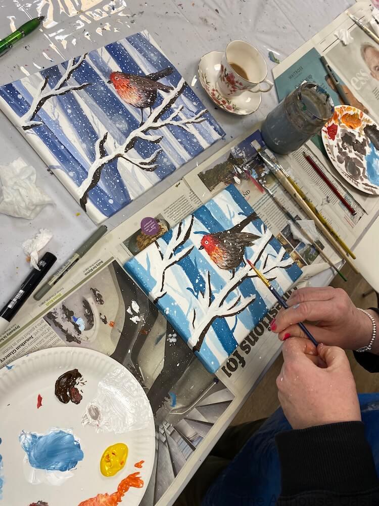 Acrylic painting of a robin on snowy branches in progress in a Bishop’s Stortford art class.