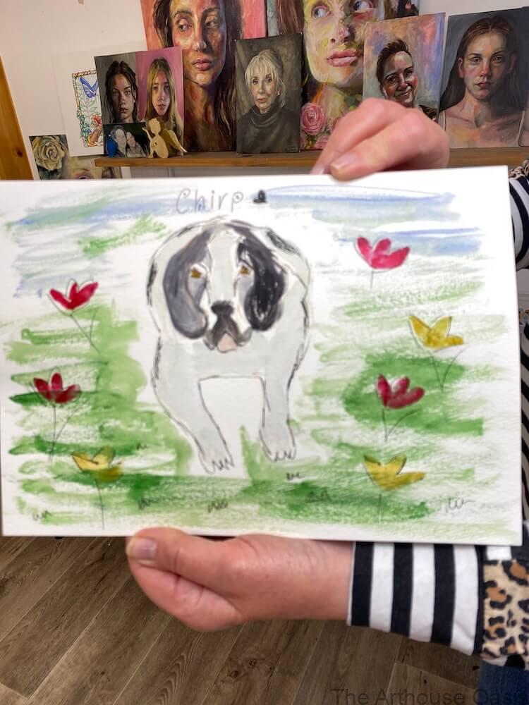 Student proudly holding a finished Saint Bernard puppy watercolour and pen painting.